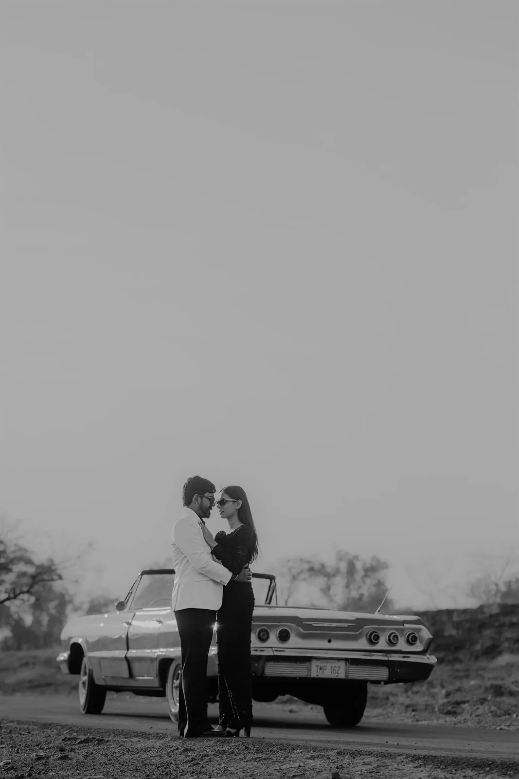 Black and white portrait with a vintage car