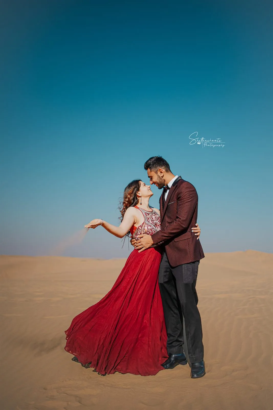 Couple in a flowing gown in the desert